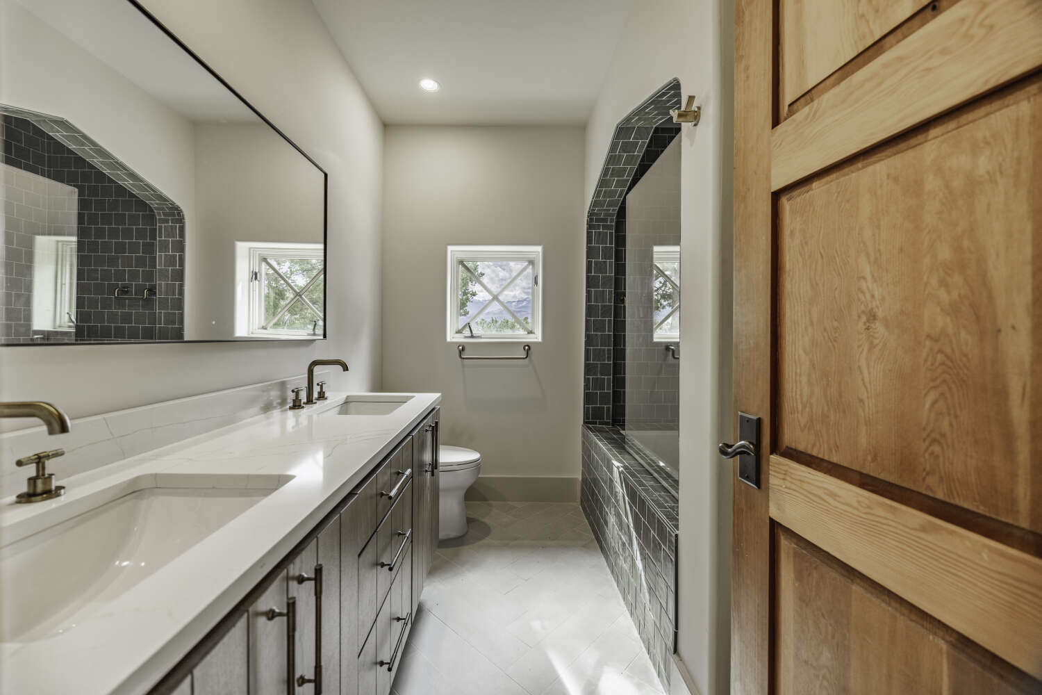 Full bathroom with arched tiled shower alcove