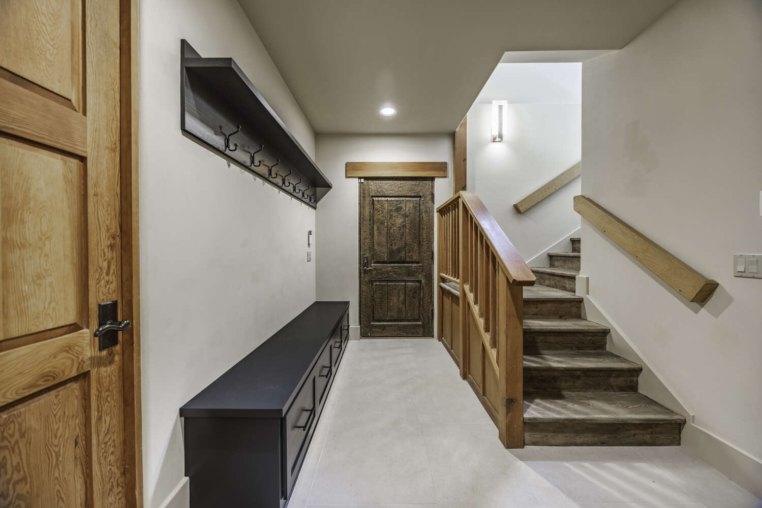 Mudroom entry with built-in bench and staircase